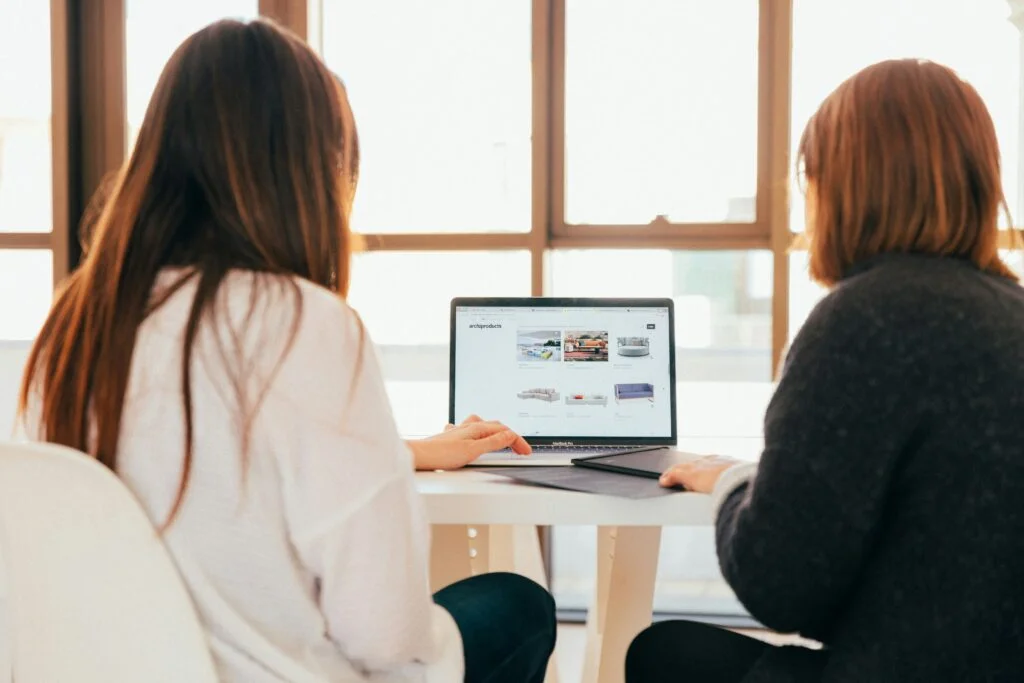 Photo by KOBU Agency on Unsplash représentant deux femmes regardant un ordinateur